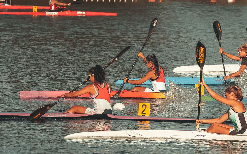 Gara sprint di K1 femminile: atleta in primo piano con la canottiera rossa e bianca del CNO, spruzzi, cartellino di corsia 2
