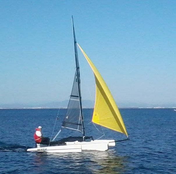 Il trimarano Weta di Sergio Cavaliere con il gennaker giallo in navigazione nel Golfo, lui a bordo con il giubbotto rosso