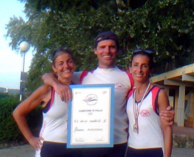 Tre atleti Master del CNO in canottiera bianca e rossa, uno con il diploma di campione italiano e una con la medaglia al collo
