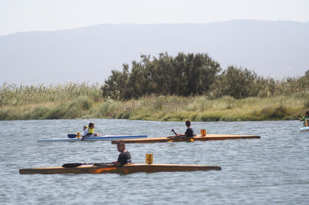 Tre kayak con i numeri 3, 4 e 7 sul fiume Tirso, canneto e montagna in controluce
